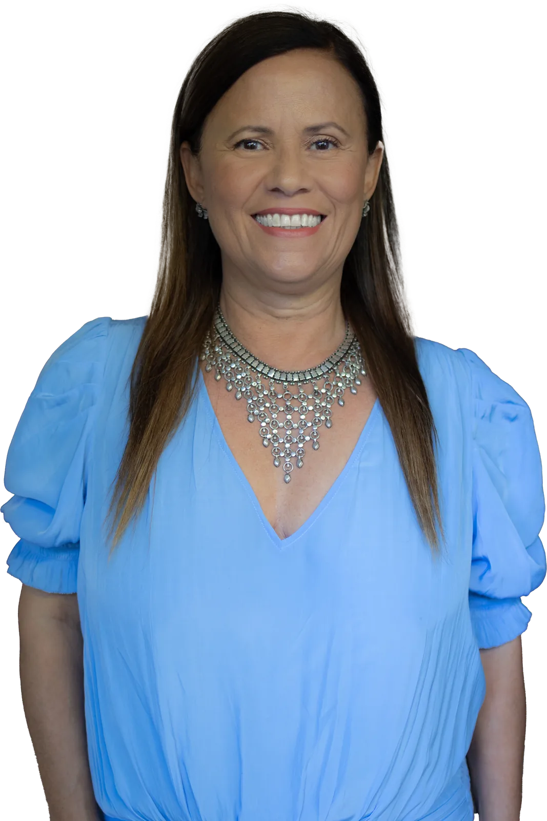Isa Herrera smiling directly at the reader, hair down, in a light blue blouse and a silver statement necklace.
