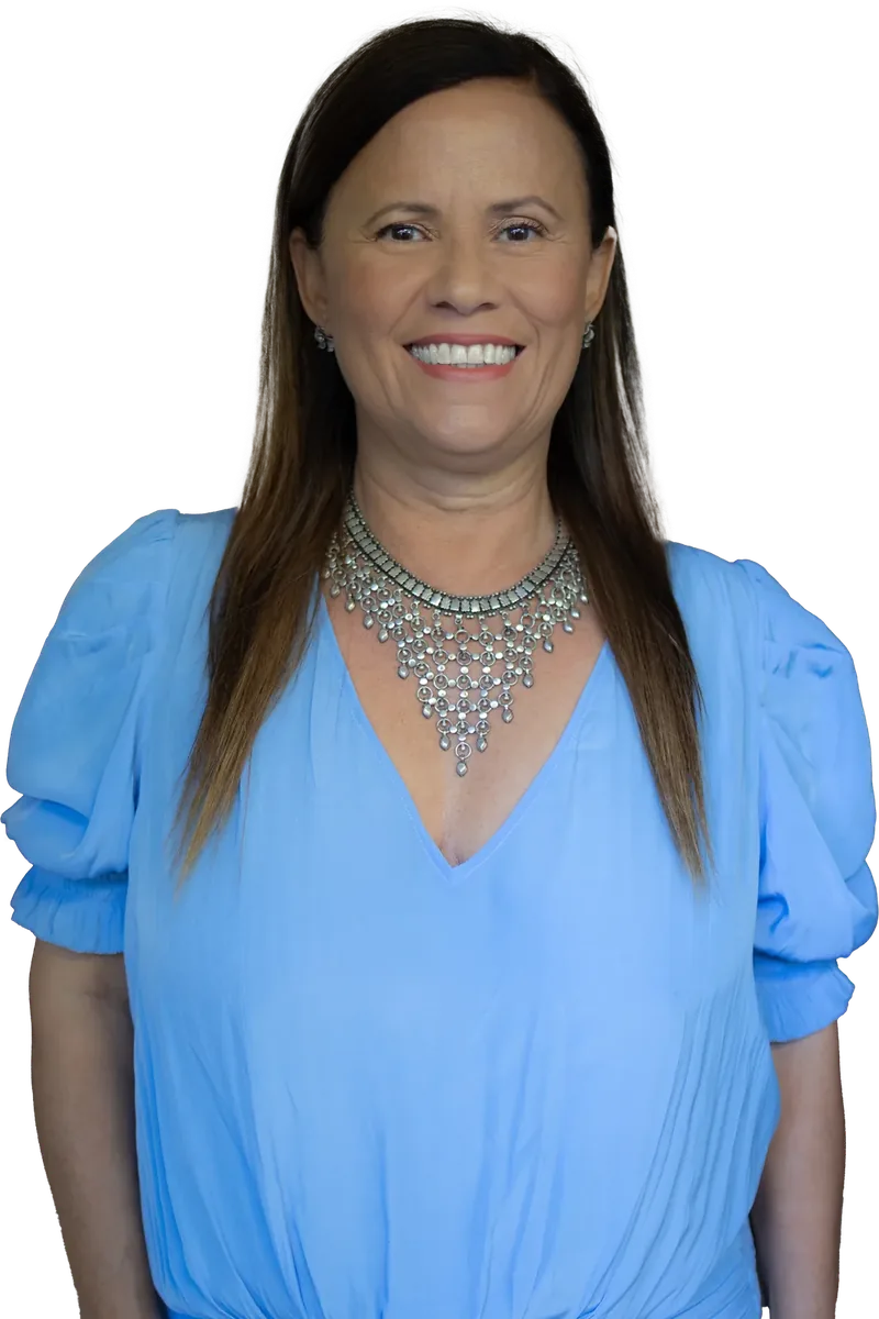 Isa Herrera smiling directly at the reader, hair down, in a light blue blouse and a silver statement necklace.